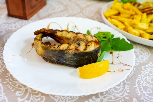 Grilled sturgeon steak with lemon