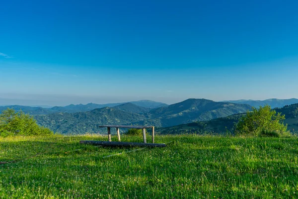 カルパティア山脈日の出のベンチと緑の牧草地からの風景 Apetska山 — ストック写真