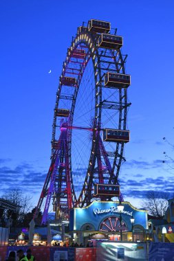 Ferris wheel in the evening in the large amusement park 
