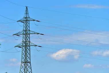 High voltage pylon with clouds and blue sky