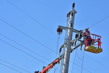 Worker at work on a power pole, Upper Austria clipart