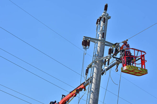 Worker at work on a power pole, Upper Austria
