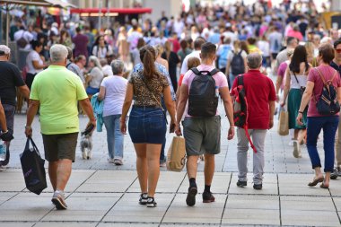 Street scene in the City of Munich with many busy people walking from behind