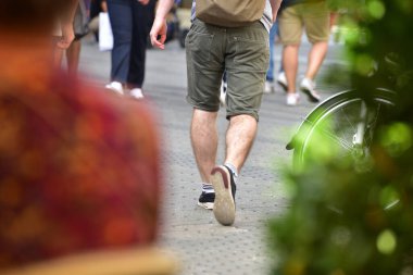 Street scene with many people walking from behind