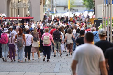 Street scene in the City of Munich with many busy people walking from behind