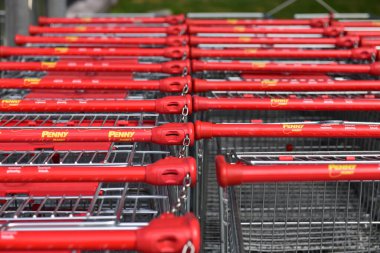 Bir bozuk para işaretinin önünde alışveriş arabaları.