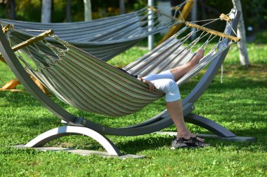 Bir kadın hamakta yatıyor.