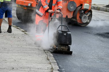 Yol inşaatında asfaltı sıkıştırmak için bir plaka sıkıştırıcı