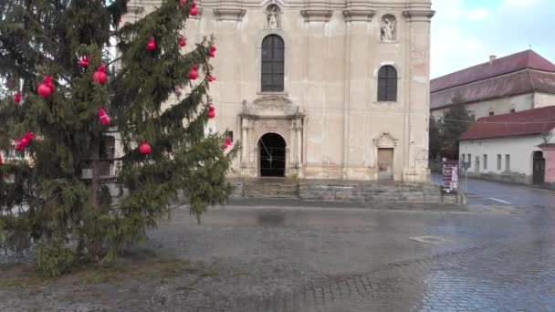 18世紀に建設されたバロック様式のアルメニア教会は、トランシルヴァニア州シビウ郡ダンブラヴェニにある。入口にはクリスマスツリーが立っています — ストック動画