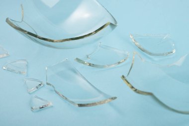 Pastel mavi arka planda kırık cam parçaları..