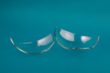 Pastel mavi yeşil arka planda kırık cam parçaları..