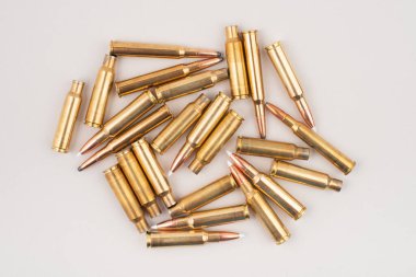 Gri arka planda izole edilmiş tüfek mermisi yığını. Üst görünüm.