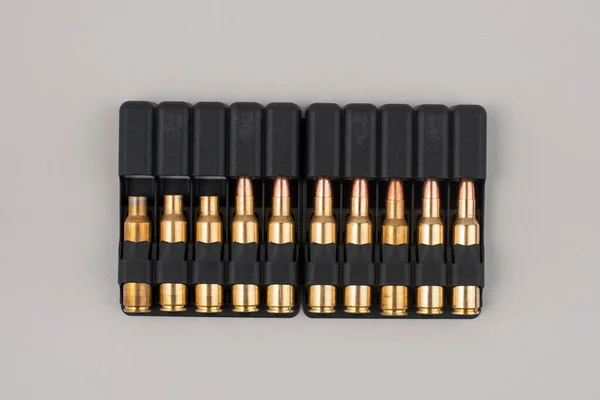 Rifle kogels in plastic koffers geïsoleerd op grijze achtergrond. — Stockfoto