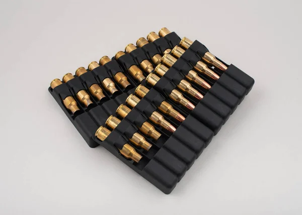 Гвинтівкові кулі в пластикових футлярах ізольовані на сірому фоні . — стокове фото