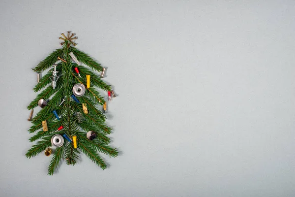 Árbol de Navidad decorado con clavos y tornillos sobre fondo gris. —  Fotos de Stock