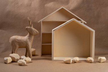 Minimum ekolojik Noel konsepti. Ahşap ve kağıttan yapılmış ev ve geyik. DIY organik sürdürülebilir Noel dekorasyonu.