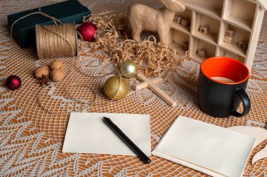 Noel tatili için hazırlık. Dekorasyon masası, bir fincan kahve, kalem ve tebrik kartı..