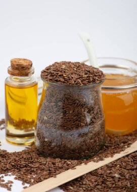 Kahverengi keten tohumu, keten tohumu yağı ve bal beyaz arka planda. Ev yapımı kozmetik malzemeleri..