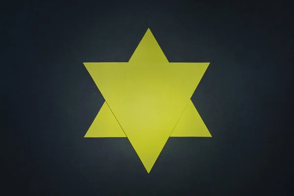 Yellow star of David on dark green background. Symbol for Holocaust memory day. — Stockfoto