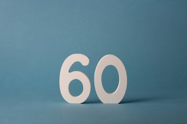 Beyaz ahşap numara 60 mavi zemin üzerinde.