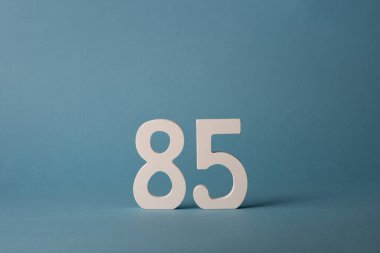 Beyaz ahşap numara 85. Mavi arka planda 85..