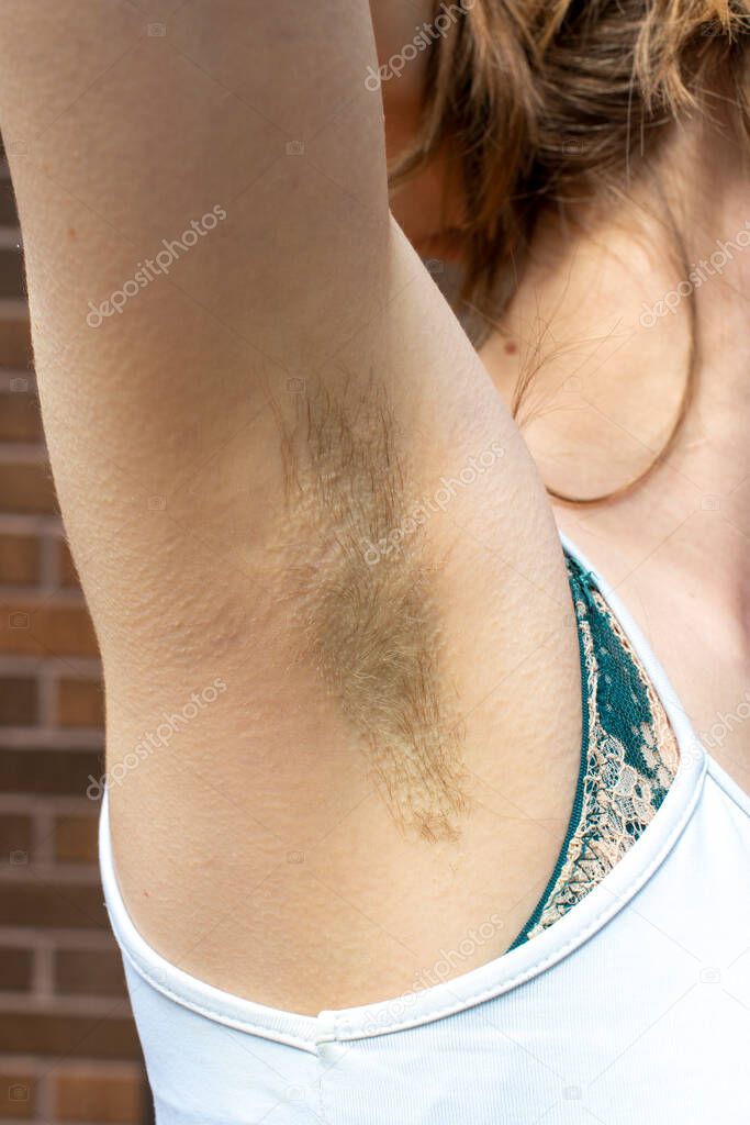 Natural unshaved hairy armpits of a body positive young woman. Close up.