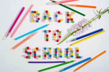 Inscription Back To School made of number beads. Decorated by flower and colourful pencils. Back to school concept. Flat lay, top view.