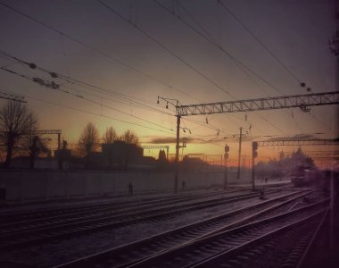 Manzara. Demiryolunda gün doğumu. Demiryolları. Uzakta treni ve merdiven binasını görebilirsiniz. Seyahat estetiği.