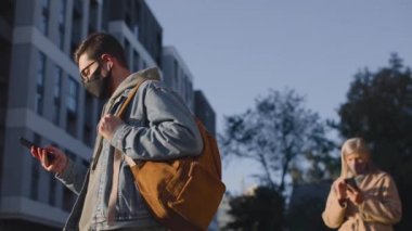 Kadın ve erkeğin güvenlik mesafesinde dikilip aletlerini kullandıkları belden yukarı portre görüntüsü.