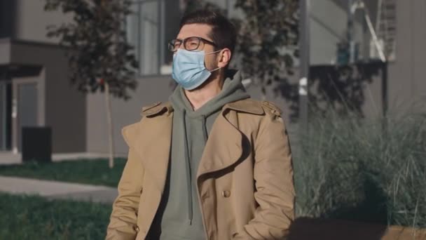 Sick unhealthy young man feeling unwell and sneezing. Ill male suffering from flu or fever and having health problems while standing at the street — Stock Video