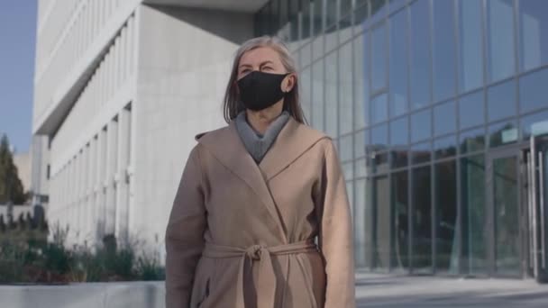 I protected my live. Motion camera view of the caucasian senior woman posing at the protective mask and looking to the camera while feeling safety — Stock Video