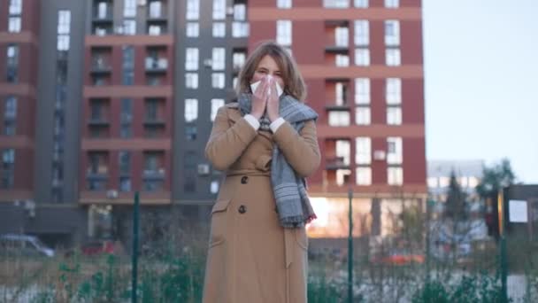 Kaukasisch krank gut aussehende Seniorin niest und pustet Nase in Serviette. Kranke Frauen niesen auf der Straße im Stadtzentrum. Ungesundes Menschenbild — Stockvideo
