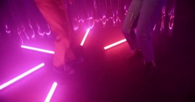 Kırmızı ceketli, gümüş zincirli ve güneş gözlüklü genç adam neon lambaların arasında balıkçı ağlı genç bir kadınla dans ediyor. Kız ve erkek geceyi gece kulübünün renkli ışıklarıyla geçirirler..