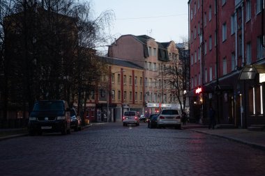 Yol eski kaldırım taşlarıyla döşeli, araba akşamları sürüyor, eski evler birbirine yakın. Kalininingrad şehri 15 Kasım 2021