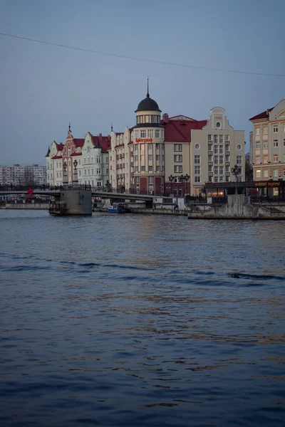 Akşam alacakaranlıkta şehir, ön planda nehir, uzakta eski şehir ve bir köprü.