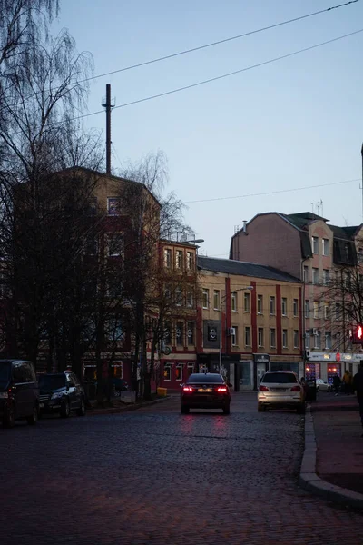 자동차는 어둑어둑 저녁에 역사적 건축적 거리를 다닌다 — 스톡 사진