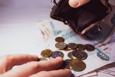 Seçici odaklanma. Rus paraları ve banknotları. El boş bir cüzdan tutuyor, ikinci el paraları sayıyor. - Yakın plan..