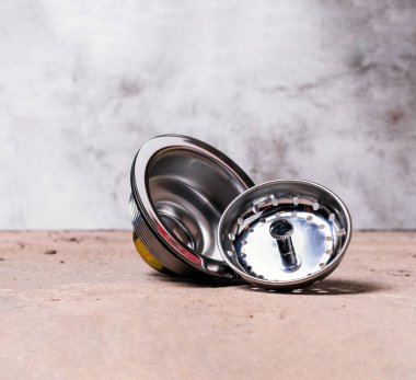 Paslanmaz çelik mutfak lavabosunun kırsal arka plandaki süzgecinin görüntüsü. Tesisat araçları arzı.