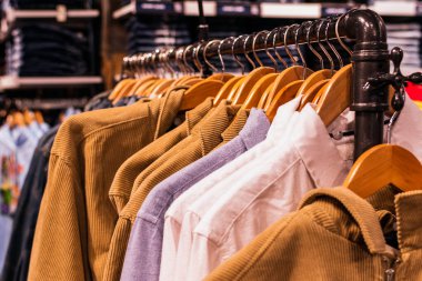 Winter sweaters on wooden hangers. Trendy fashion autumn warm and cozy clothes winter concept. Copy Space