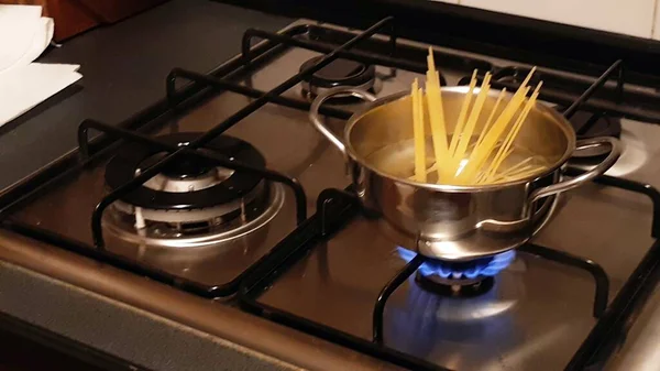 Flame Gas, Household energy consumption. Spaghetti in the pot in the kitchen. Increased costs in the bill.