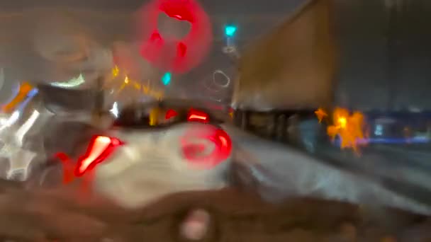 Natte weg, close-up, auto 's rijden langs een nachtelijke winterstraat. Sneeuw met regen op de voorruit van de auto. Voertuigen rijden op natte regenachtige gladde weg bij slecht weer. — Stockvideo