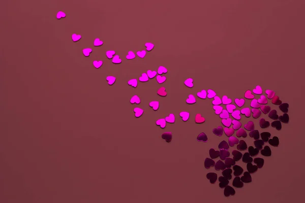 Hartbrekend concept. Abstracte gebroken hart van confetti op een rode achtergrond. Of liefde romantisch paar, Valentijnsdag concept. — Stockfoto
