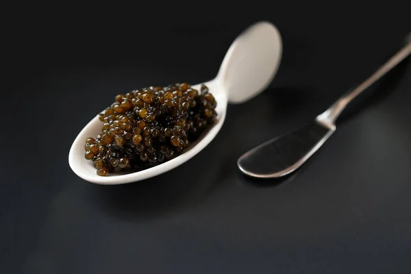 Caviar Preto Natural Uma Colher Porcelana Serviço Branco Fundo Escuro — Fotografia de Stock