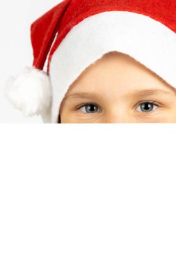 Noel Baba şapkalı çocuk yüzünün yarısı beyaz arka planda izole edilmiş beyaz boş bir kartın arkasında.