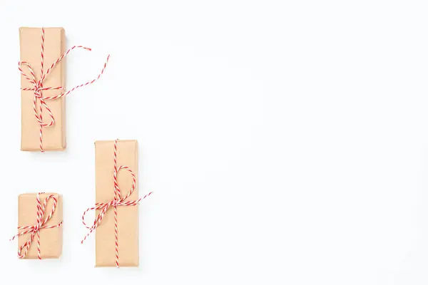 En üstteki noel tebrik kartı el işi kağıt hediyelere sarılmış kırmızı halatla bağlanmış fotokopi alanı, beyaz arka planda izole edilmiş — Stok fotoğraf