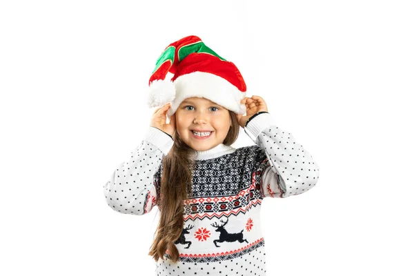 Close-up portrait of smiling, positive girl in white knitted Christmas sweater with reindeer holding gnome hat with hands, isolated on white background — Stock Photo, Image