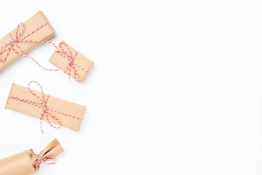 Düz oyun Noel hediyesi. Farklı şekillerde kırmızı iple sarılı. Fotokopi alanının solunda.