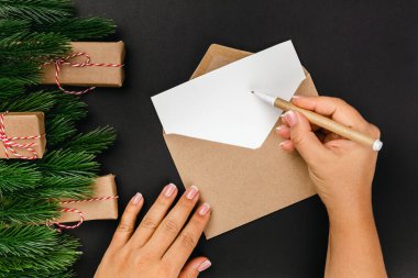  Eller aileyi tebrik eder ve siyah arka planda Noel ağaçları ve hediye kutuları olan mektuplar gönderir.