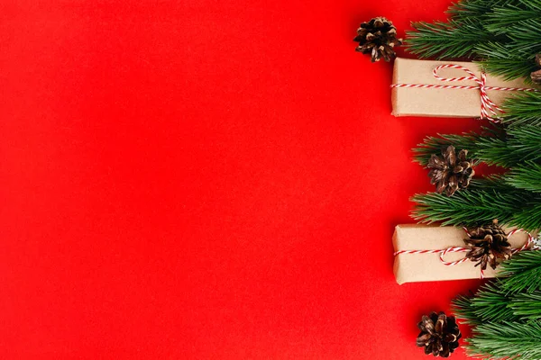 Fondo de Navidad aislado rojo con espacio de copia con marco de ramas de árbol de Navidad, conos y cajas de regalo — Foto de Stock