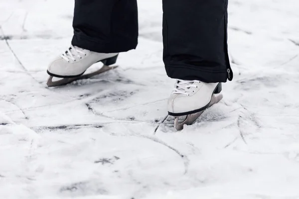 Figure skating skates. Close-up of mans feet standing on skates on ice of a frozen lake